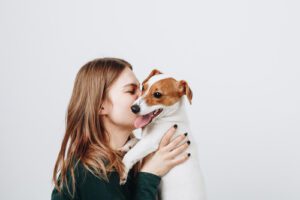 young-woman-holding-small-dog-in-her-arms-and-kissing-his-face